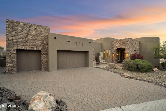 15424 E Sundown Dr, Fountain Hills, AZ 85268 - adobe home with an attached garage, stone siding, decorative driveway, and stucco siding