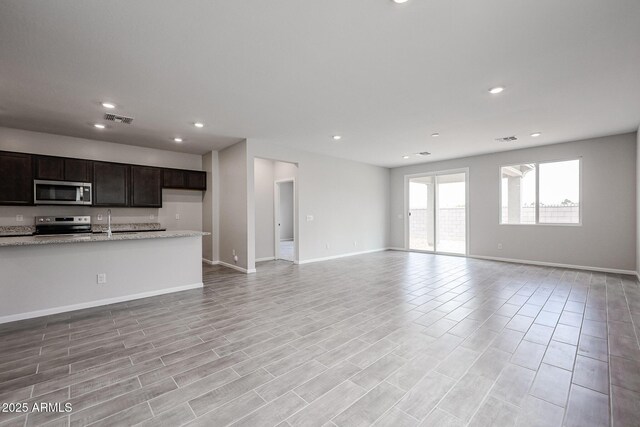 2614 E Music Mountain Ave, Apache Junction, AZ 85119 - unfurnished living room with recessed lighting, baseboards, a sink, and light wood-style floors