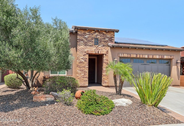 view of front of property with solar panels and a garage