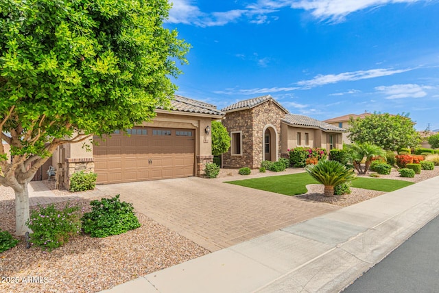 3400 S Whetstone Pl, Chandler, AZ 85286 - mediterranean / spanish-style home with stone siding, decorative driveway, stucco siding, and a garage