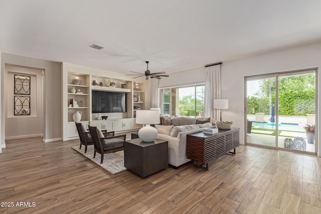 3400 S Whetstone Pl, Chandler, AZ 85286 - living room with wood finished floors, ceiling fan, baseboards, and built in shelves
