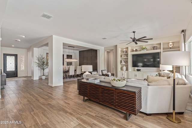 3400 S Whetstone Pl, Chandler, AZ 85286 - living area with ceiling fan, wood finished floors, built in shelves, and baseboards