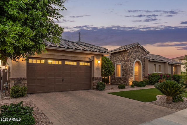 3400 S Whetstone Pl, Chandler, AZ 85286 - mediterranean / spanish-style home featuring stone siding, decorative driveway, a tile roof, and a garage