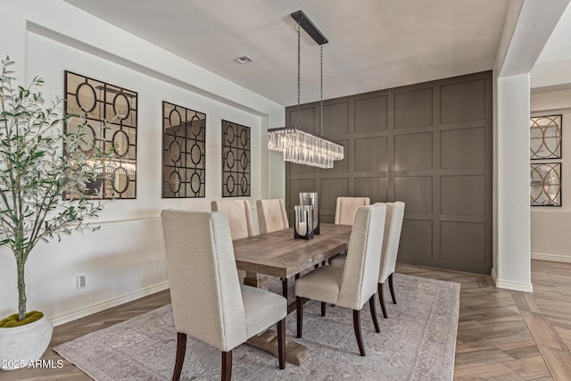 3400 S Whetstone Pl, Chandler, AZ 85286 - dining room with baseboards, a decorative wall, a chandelier, and parquet flooring