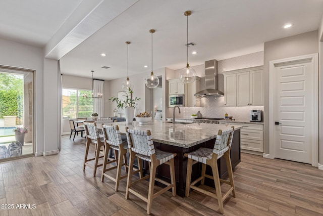 3400 S Whetstone Pl, Chandler, AZ 85286 - kitchen featuring wall chimney exhaust hood, stainless steel appliances, a sink, backsplash, and a breakfast bar area