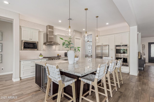 3400 S Whetstone Pl, Chandler, AZ 85286 - kitchen with wall chimney exhaust hood, built in appliances, backsplash, light wood finished floors, and recessed lighting