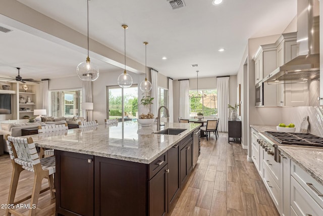 3400 S Whetstone Pl, Chandler, AZ 85286 - kitchen featuring wall chimney exhaust hood, a sink, appliances with stainless steel finishes, open floor plan, and dark brown cabinetry