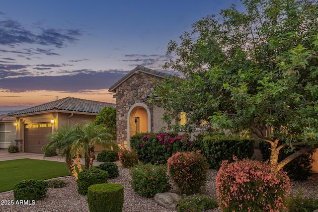 3400 S Whetstone Pl, Chandler, AZ 85286 - view of front of home with a tiled roof, an attached garage, stone siding, stucco siding, and driveway