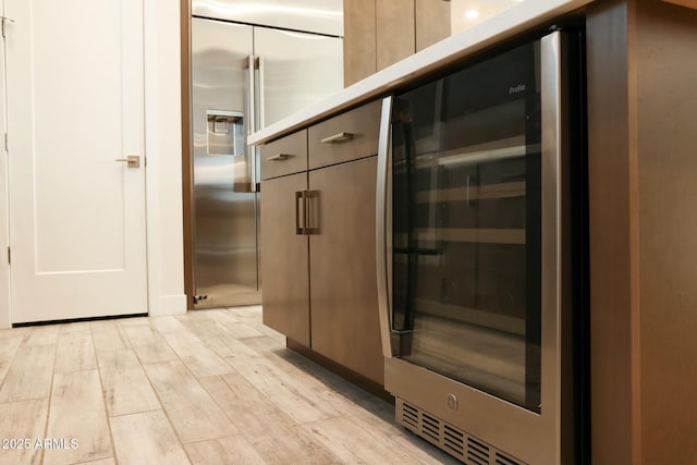 interior space with wood-type flooring, stainless steel built in fridge, and beverage cooler