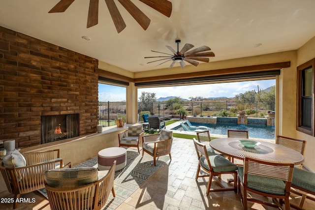 view of patio / terrace featuring an outdoor brick fireplace, pool water feature, and a fenced in pool