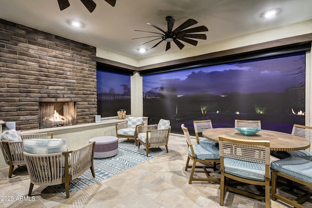 view of patio / terrace featuring ceiling fan and a fireplace