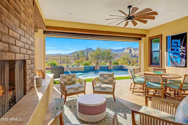 view of patio / terrace with ceiling fan, pool water feature, and a mountain view