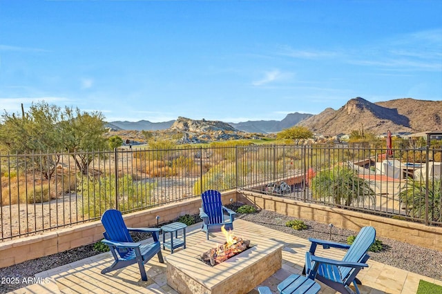 view of patio / terrace with a mountain view and a fire pit