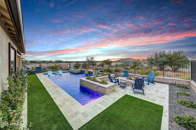 pool at dusk with pool water feature, a hot tub, a yard, a fire pit, and a patio