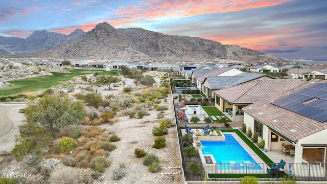 pool at dusk with a mountain view and a patio area