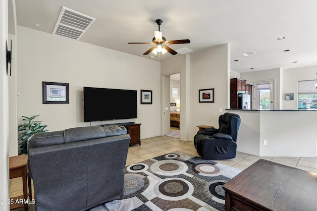 living room with ceiling fan, visible vents, and light tile patterned floors