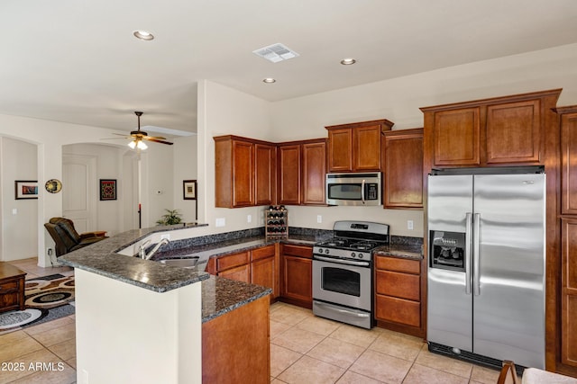 kitchen featuring a sink, visible vents, a ceiling fan, a peninsula, and appliances with stainless steel finishes