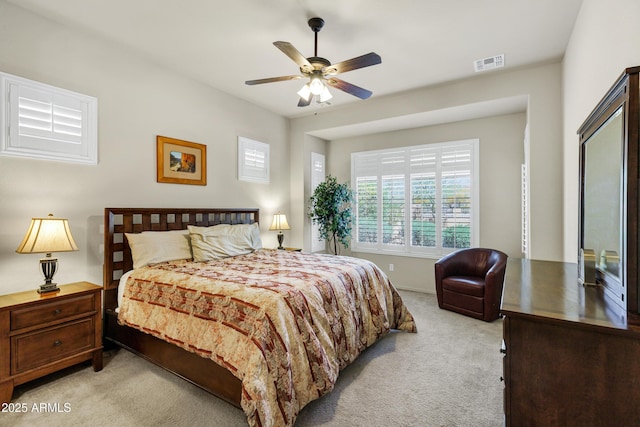 bedroom with light colored carpet, visible vents, and ceiling fan