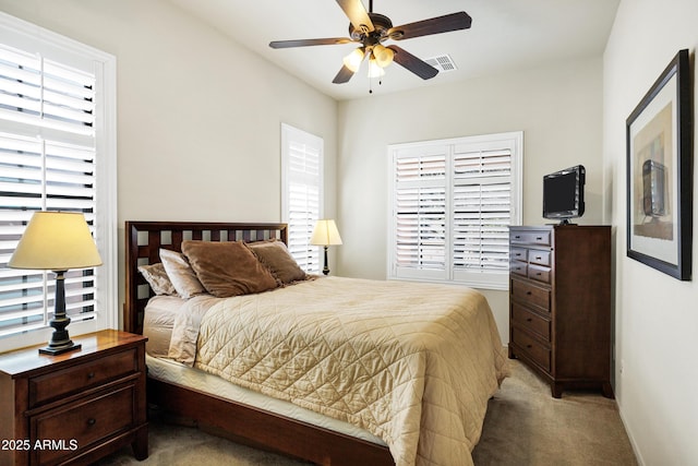 bedroom with a ceiling fan, light colored carpet, and visible vents