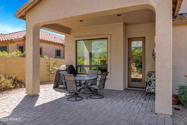 view of patio featuring outdoor dining area and fence