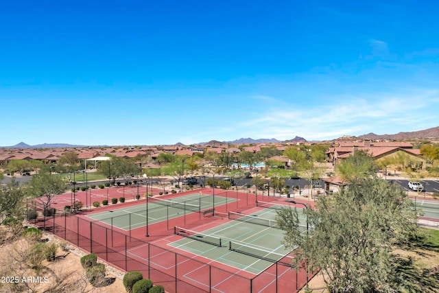 view of tennis court with a mountain view and fence