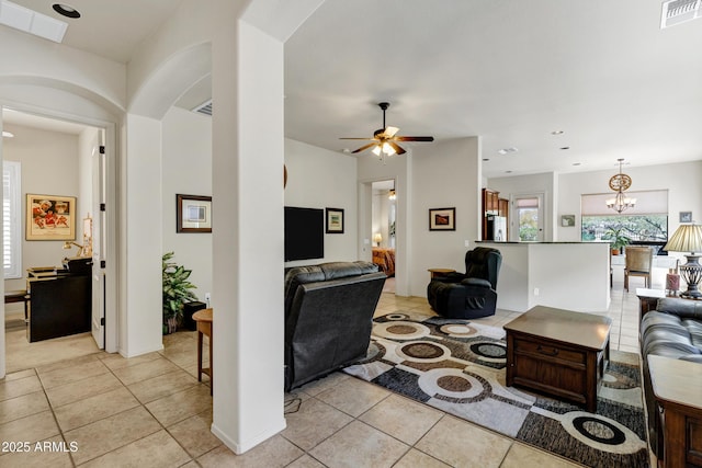 living room featuring ceiling fan with notable chandelier, visible vents, and light tile patterned floors