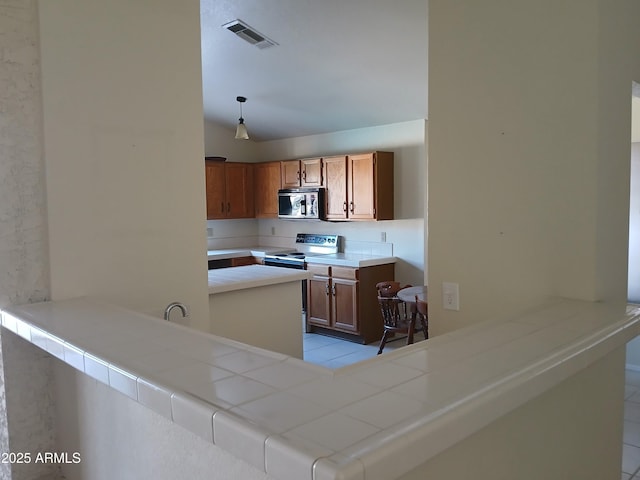 kitchen featuring pendant lighting, electric range, tile countertops, and kitchen peninsula