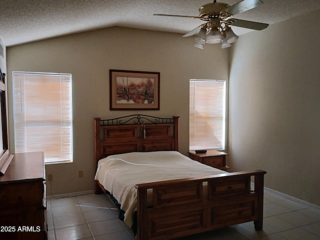 bedroom featuring ceiling fan, lofted ceiling, light tile patterned floors, and a textured ceiling