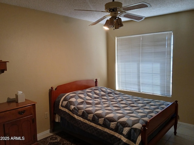 bedroom with ceiling fan and a textured ceiling