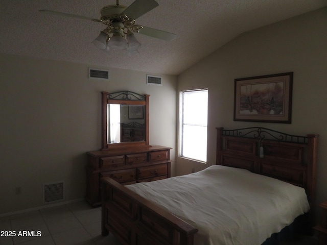 tiled bedroom with ceiling fan, lofted ceiling, and a textured ceiling