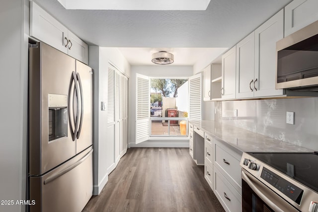 kitchen featuring white cabinetry, backsplash, dark hardwood / wood-style flooring, and appliances with stainless steel finishes