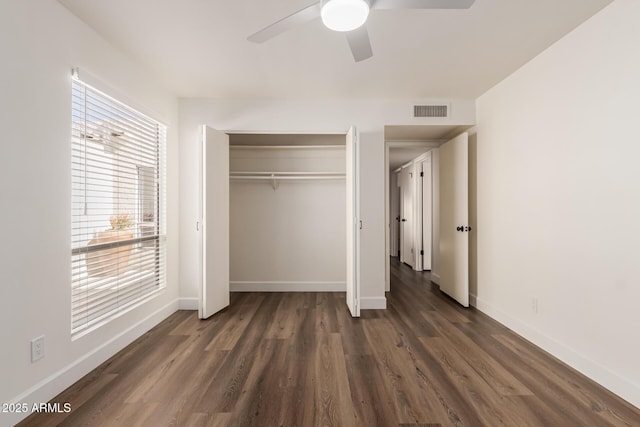 unfurnished bedroom with dark wood-type flooring, a closet, and ceiling fan