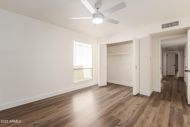 unfurnished bedroom with dark hardwood / wood-style flooring, a closet, and ceiling fan