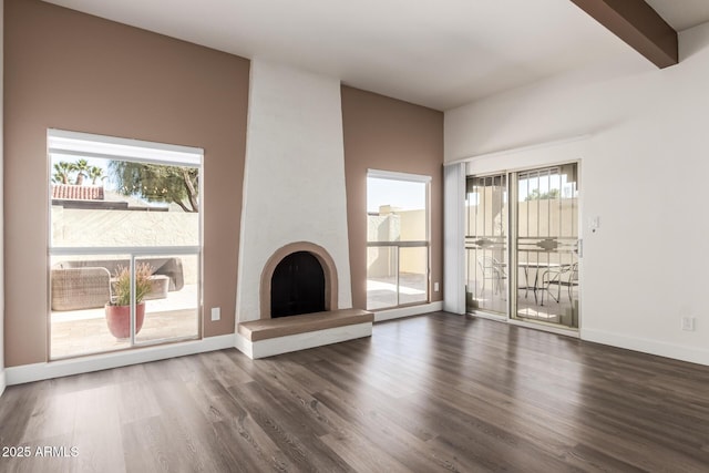 unfurnished living room featuring beamed ceiling, a fireplace, and dark hardwood / wood-style floors