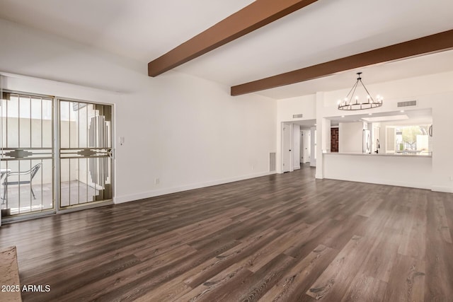 unfurnished living room with beamed ceiling, plenty of natural light, dark hardwood / wood-style floors, and an inviting chandelier