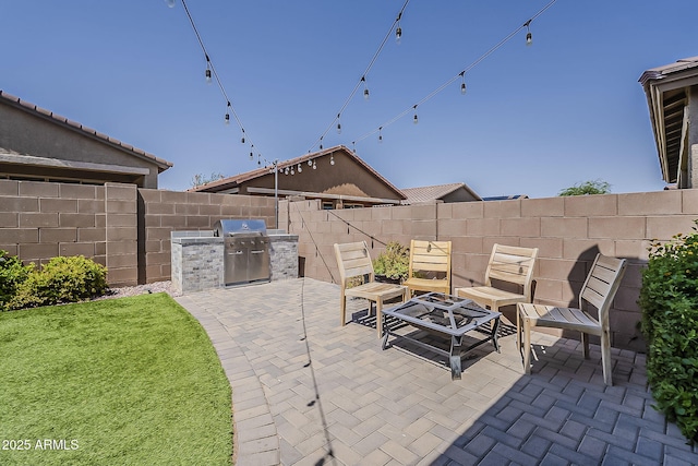 6566 E Via Arroyo Largo, Tucson, AZ 85756 - fenced backyard featuring a patio, an outdoor kitchen, and an outdoor fire pit
