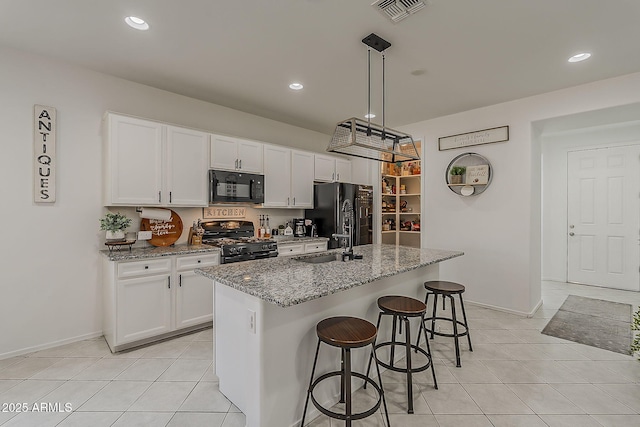 6566 E Via Arroyo Largo, Tucson, AZ 85756 - kitchen with black appliances, light tile patterned flooring, white cabinets, and recessed lighting