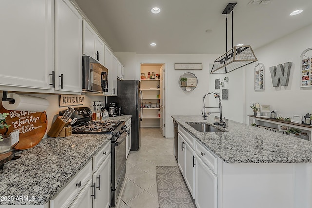 6566 E Via Arroyo Largo, Tucson, AZ 85756 - kitchen with black appliances, white cabinetry, a kitchen island with sink, recessed lighting, and light stone countertops