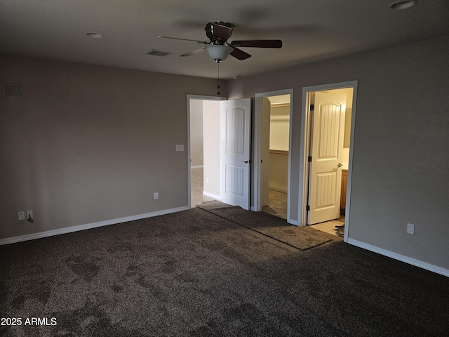 unfurnished bedroom featuring ceiling fan, a walk in closet, and carpet floors