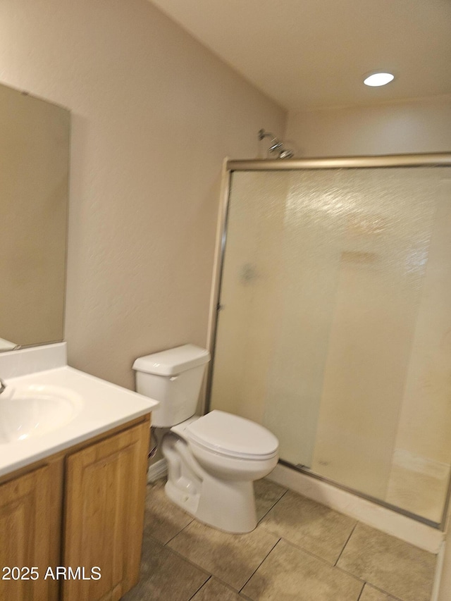 bathroom with vanity, tile patterned flooring, toilet, and walk in shower