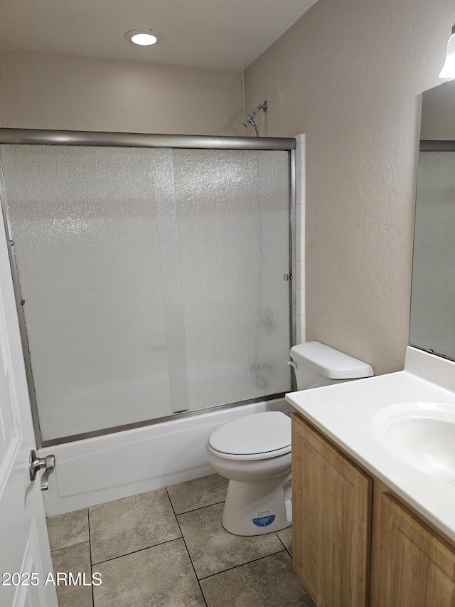 full bathroom with toilet, vanity, bath / shower combo with glass door, and tile patterned flooring