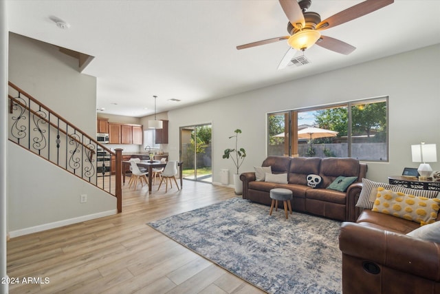 living room featuring light hardwood / wood-style floors and ceiling fan