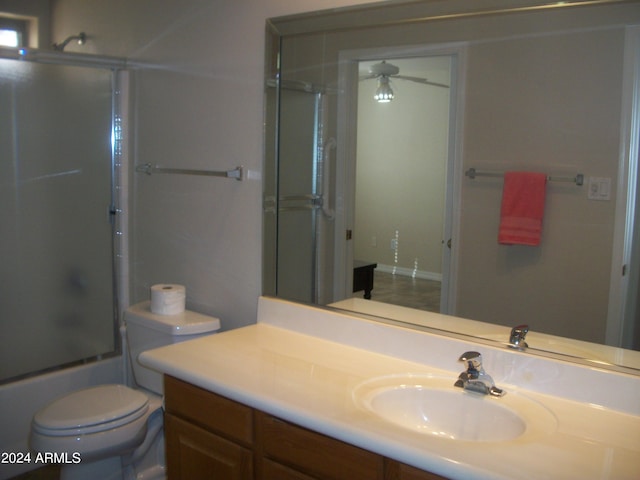 full bathroom featuring ceiling fan, shower / bath combination with glass door, vanity, and toilet