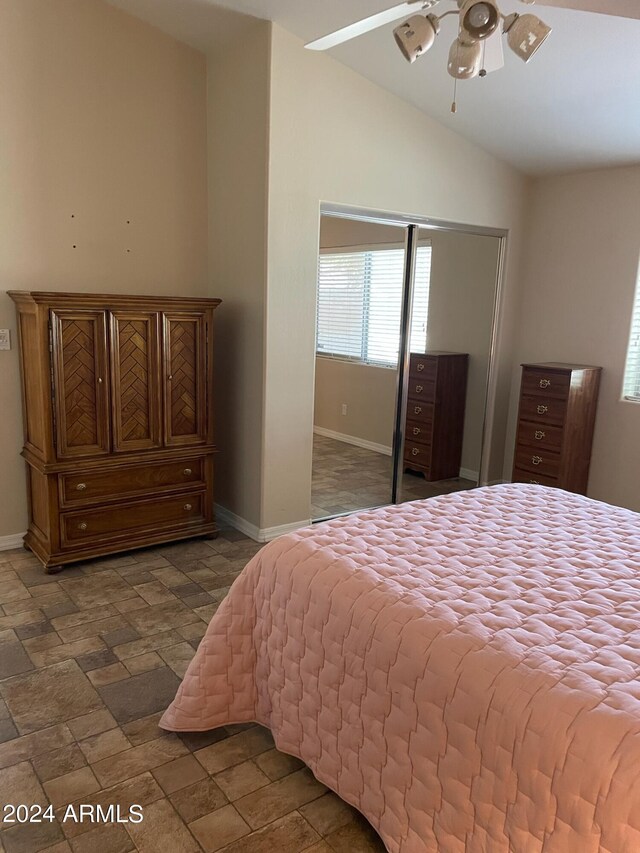 5830 E Mckellips Rd Unit 62, Mesa, AZ 85215 - bedroom with baseboards, stone tile floors, lofted ceiling, and a closet