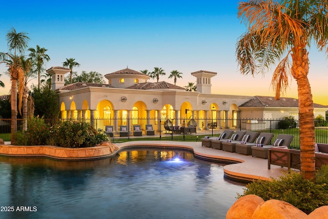 pool at dusk featuring a patio