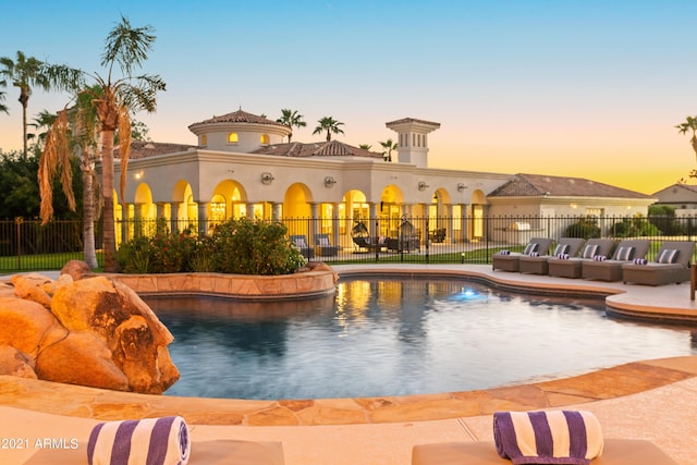 pool at dusk with a patio