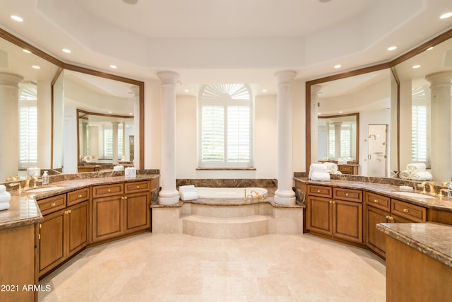 bathroom featuring ornate columns and a raised ceiling