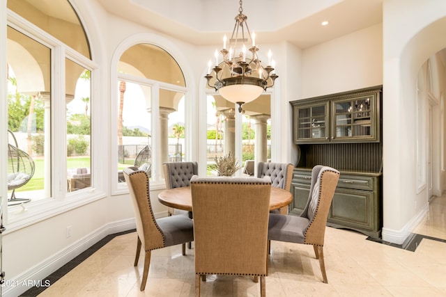 tiled dining room with a notable chandelier and a tray ceiling