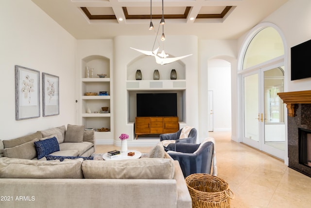 living room with a premium fireplace, beam ceiling, a high ceiling, coffered ceiling, and built in shelves