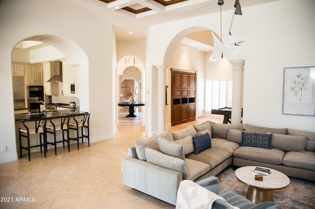 living room featuring billiards, beam ceiling, a towering ceiling, decorative columns, and coffered ceiling